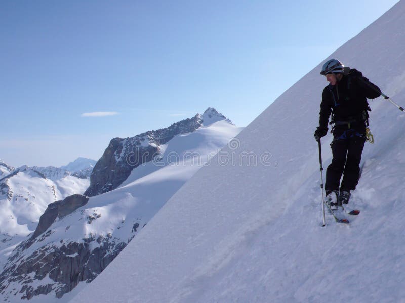 Skieur extrême au début d'une descente du nord très raide de ski de visage dans les Alpes de la Suisse photos libres de droits Skieur extrême au début d'une descente du nord très raide de ski de visage dans les Alpes de la Suisse photos libres de droits