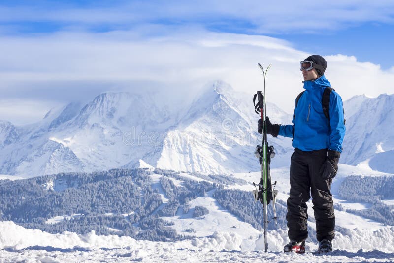 Skieur tenant des skis à disposition et en regardant le magnifique paysage couvert de neige près de Chamonix Mont Blanc France