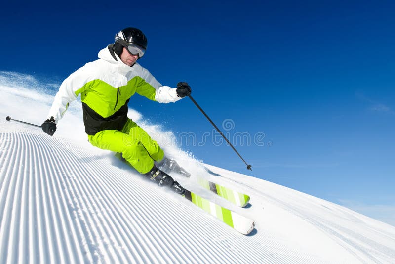 Skifahrer in den Bergen, in vorbereitetem piste und im sonnigen Tag stockfotos