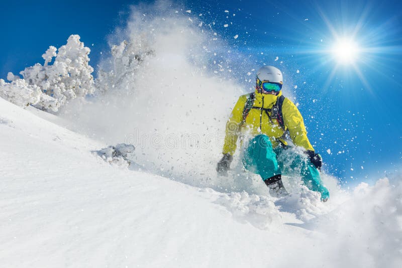 Skifahrer, der abwärts im Hochgebirge Ski fährt lizenzfreies stockbild Skifahrer, der abwärts im Hochgebirge Ski fährt lizenzfreies stockbild