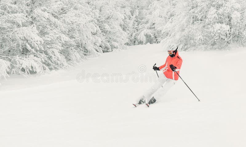 Skifahrer der jungen Frau, der abwärts auf Ski Piste läuft lizenzfreies stockbild Skifahrer der jungen Frau, der abwärts auf Ski Piste läuft lizenzfreies stockbild