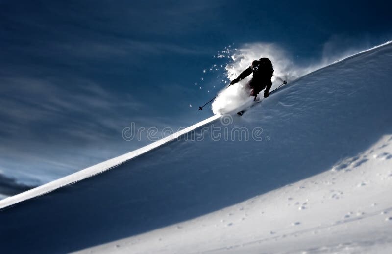 Man skiing in deep powder and making turn on edge