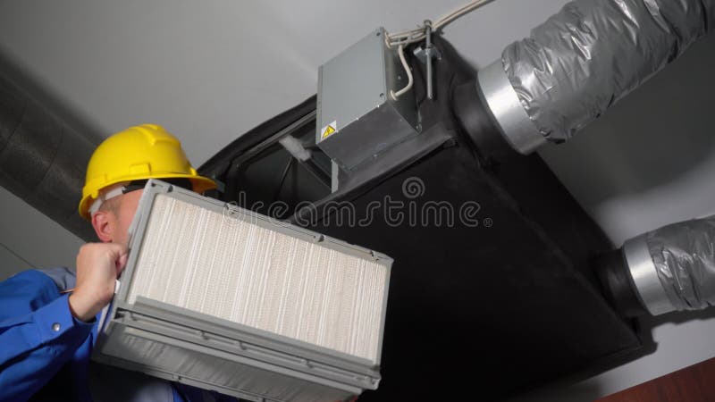 Skilled engineer man removing air ventilation system filters