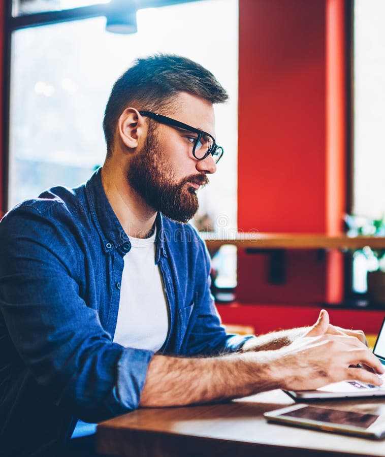 Skilled hipster guy working remotely with startup project on laptop device with copy space stock photos
