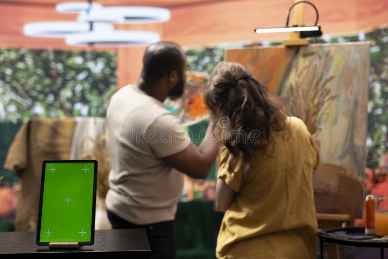 Skilled painters working on an artistic creation next to chroma key screen stock images