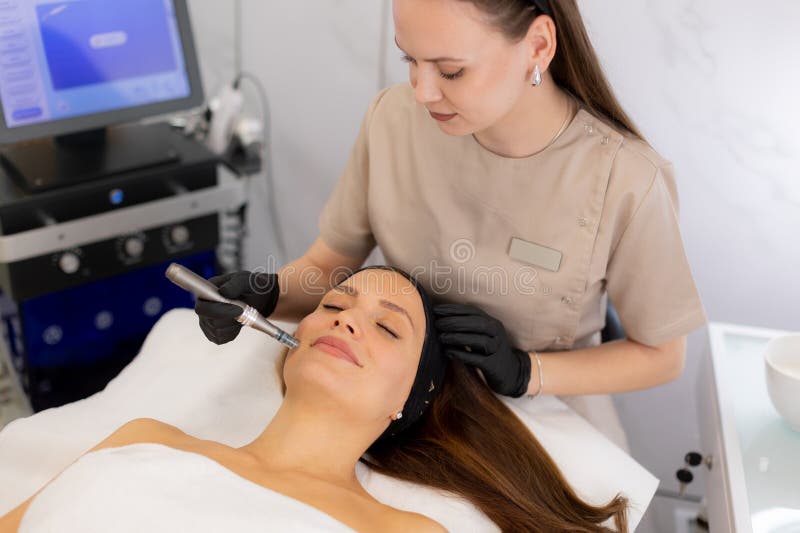 A skilled practitioner uses a microneedling mesotherapy device to revitalize a client's skin. The serene beauty clinic atmosphere complements the transformative treatment experience. Pampering experience stock images, royalty-free photos and pictures