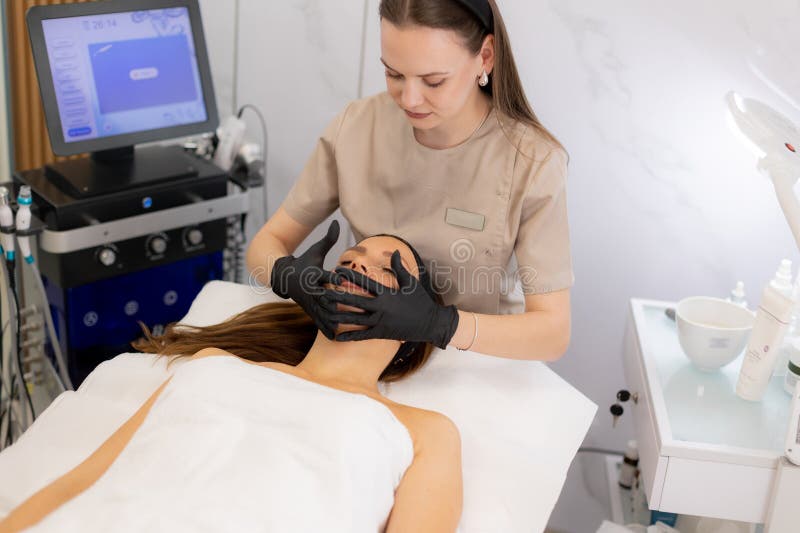 A skilled professional performs a soothing facial on a relaxed client at a tranquil spa, promoting skin rejuvenation and ultimate comfort for a peaceful experience. Pampering experience stock images, royalty-free photos and pictures