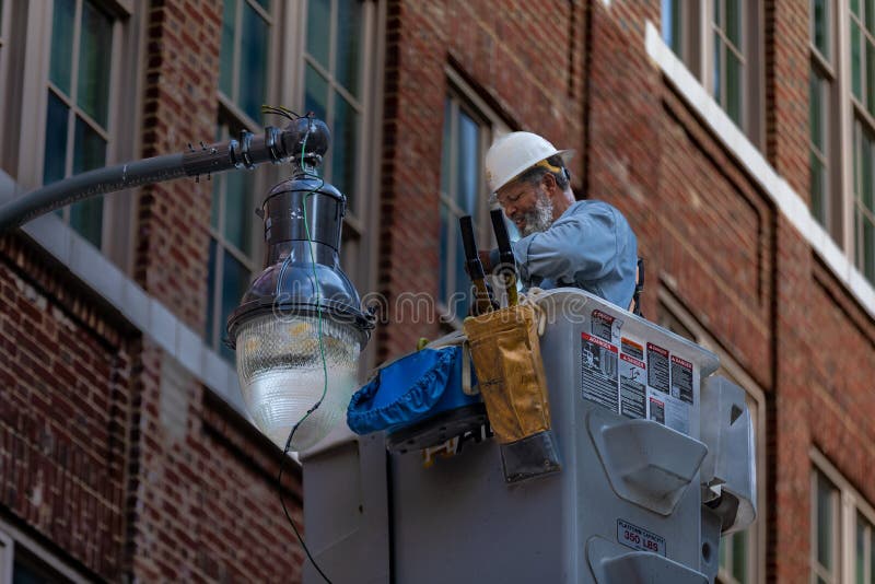 Skilled Worker Repairing a Street Light Editorial Photography Image