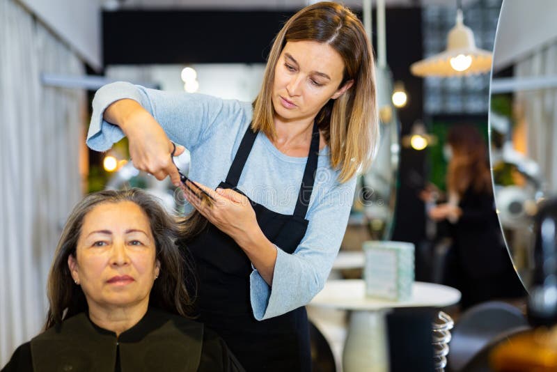 Woman Hair Stylist Making Haircut To Aged Female Client Stock Image ...