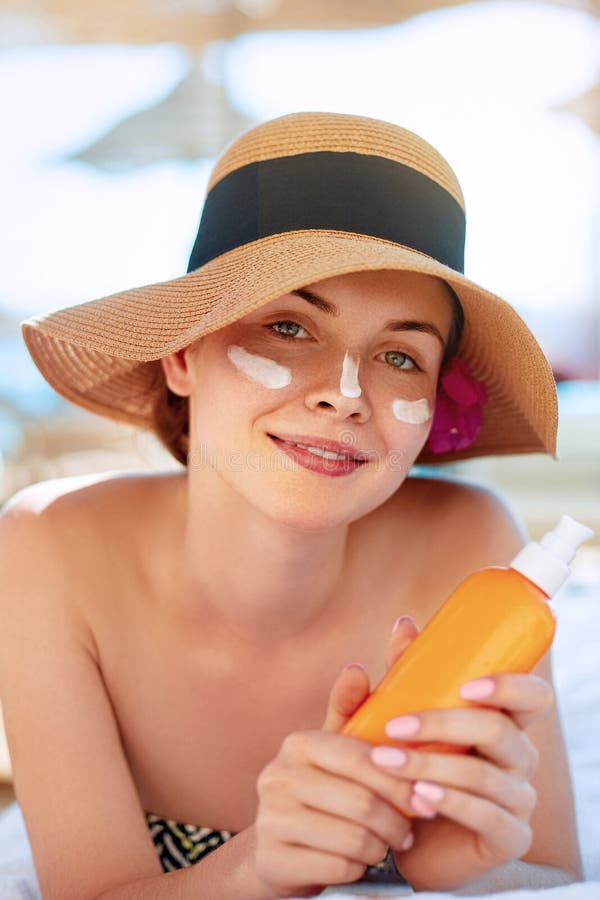 Skin care. Beauty Concept. Young pretty woman holding sun cream and applying on her face. royalty free stock photos Skin care. Beauty Concept. Young pretty woman holding sun cream and applying on her face. royalty free stock photos