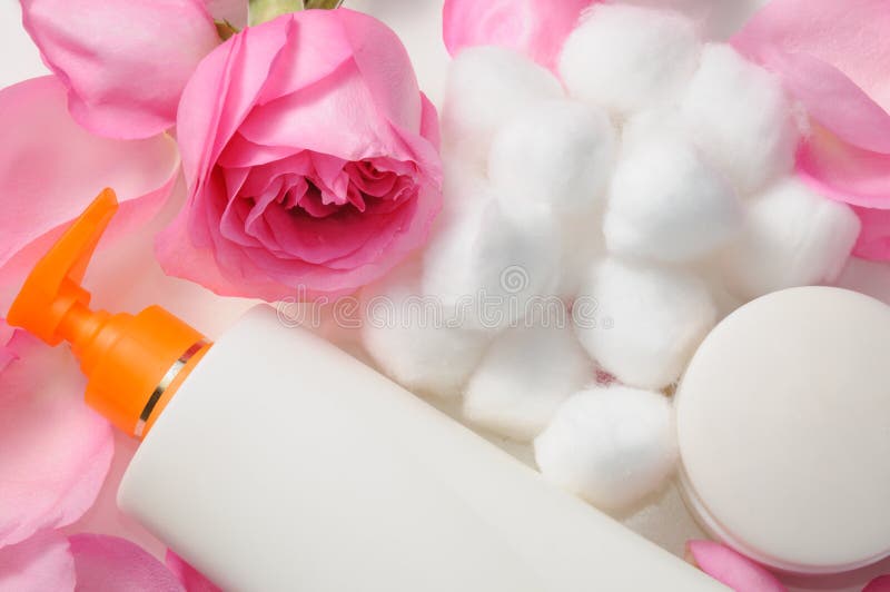 Blank skin care lotion with rose petals and cotton swabs. Blank skin care lotion with rose petals and cotton swabs
