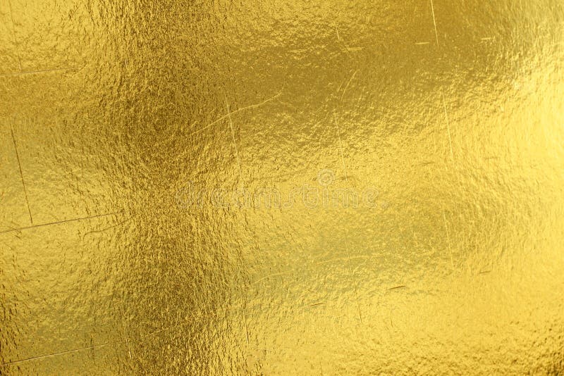 Skinande gul bakgrund för textur för guld- folie för blad arkivbilder