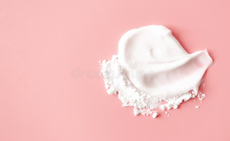 Skincare moisturizer and white transparent powder on pink background, top view. Smear cosmetic