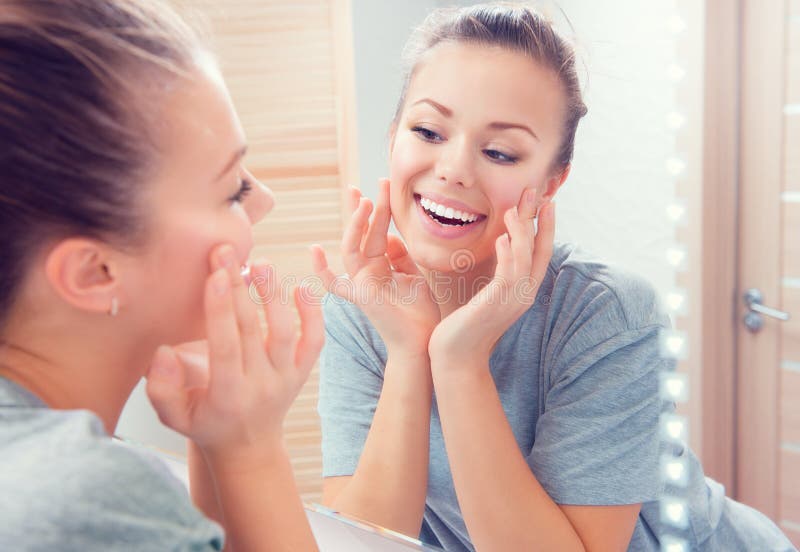 Skincare Молодой красивый девочка-подросток касаясь ее стороне стоковые фото