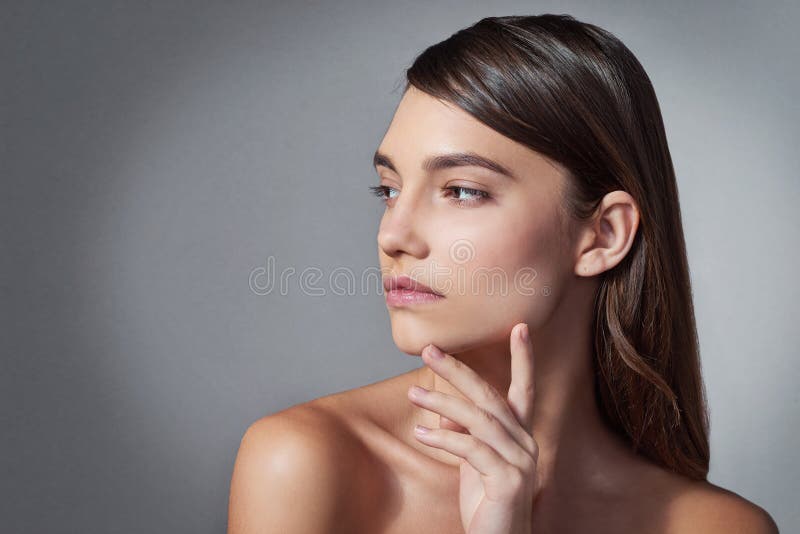 Skinnerkvinna och tänkande i studio mockup för vård av spa och smink. dermatologiflicka och idé om grå fotografering för bildbyråer