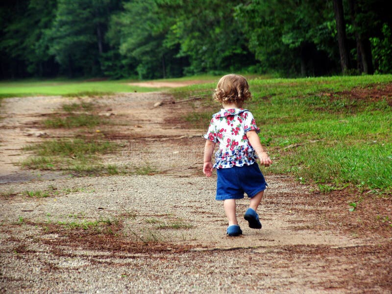 Little girl walking up a dirt road. Little girl walking up a dirt road