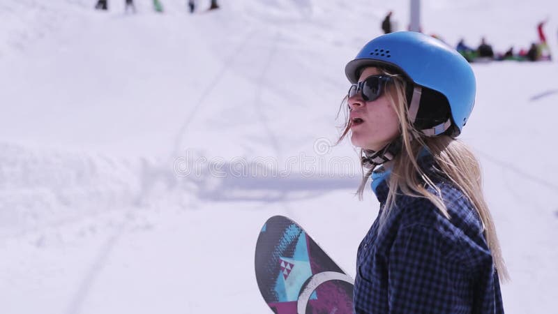 Skiresort Meisjessnowboarder in helm, zonnebril spreekt met iemand Zondag