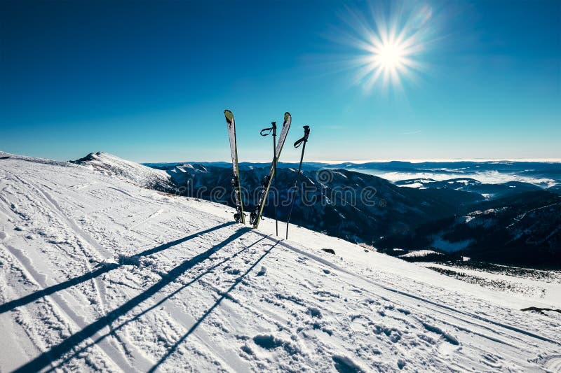 Lyže jsou v hlubokém sněhu na lyžařské trati za slunečného jasného světla