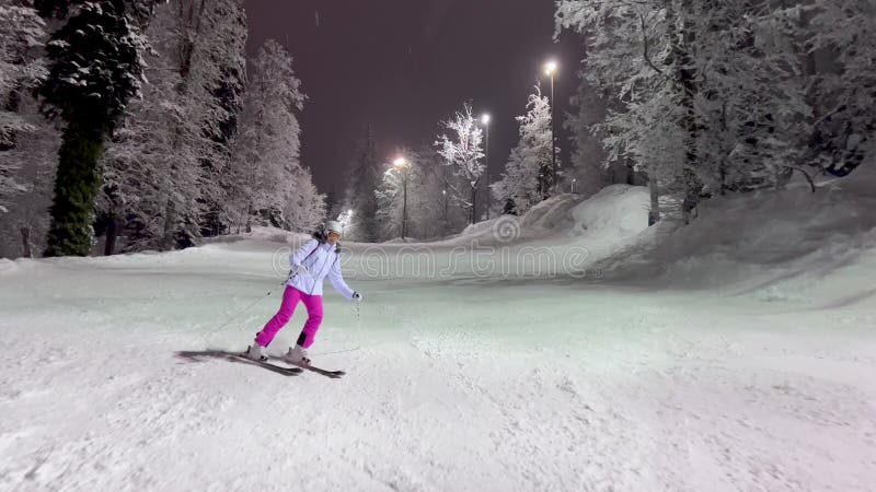 Skislep in de avond op de skihelling voor verlichting met sneeuwbedekte bomen met vorst