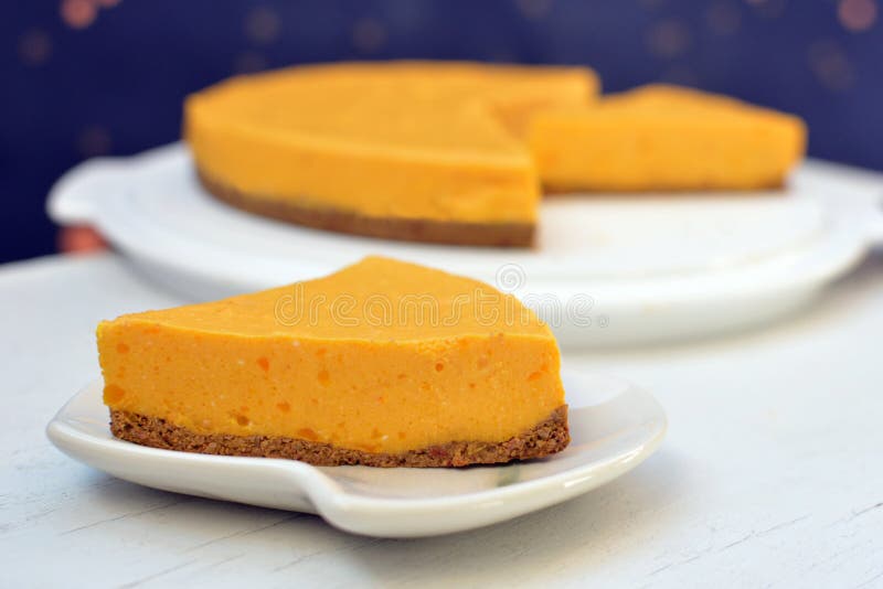 Skiva av den hemlagade orange kräm- pumpakakan på plattan arkivbilder Skiva av den hemlagade orange kräm- pumpakakan på plattan arkivbilder
