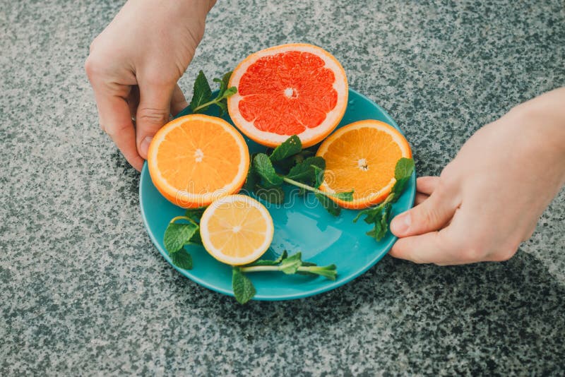 Skivad citron, apelsin, grapefrukt och mintkaramell på en blå platta, vitaminer, citrus i minimalismstil, popkonst, mörker - blå royaltyfri foto Skivad citron, apelsin, grapefrukt och mintkaramell på en blå platta, vitaminer, citrus i minimalismstil, popkonst, mörker - blå royaltyfri foto
