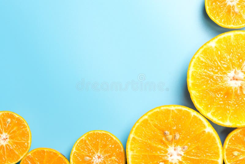 Skivade orange frukter på blå bakgrund royaltyfri fotografi
