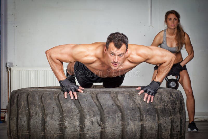 Push up on a tire crossfit training in a gym. Push up on a tire crossfit training in a gym