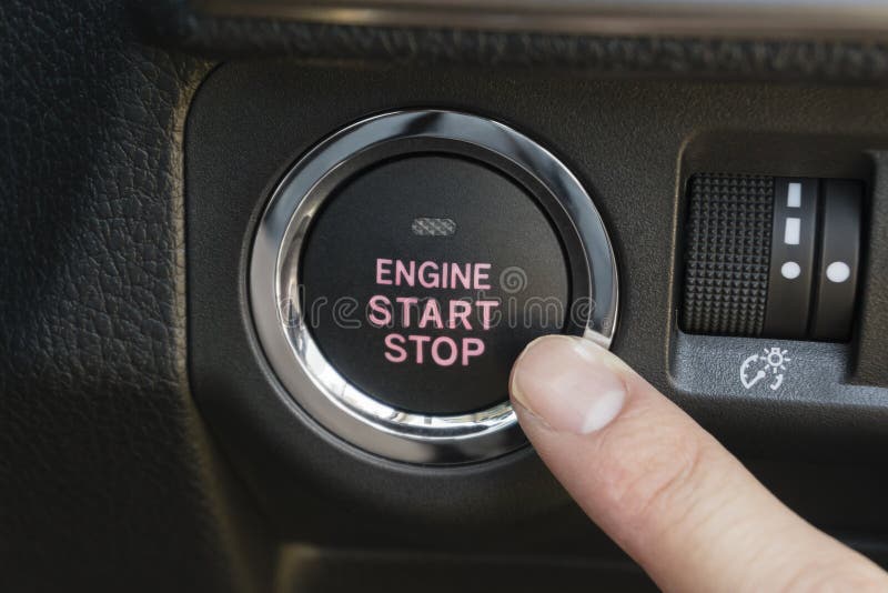 Pushing the button to start the engine of a car. Pushing the button to start the engine of a car