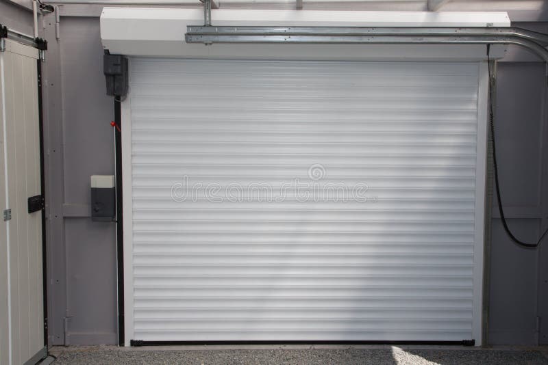 Skjuter den kommersiella garageporten för automatisk elektrisk rulle-upp upp dörr i modernt byggande hus arkivbilder Skjuter den kommersiella garageporten för automatisk elektrisk rulle-upp upp dörr i modernt byggande hus arkivbilder