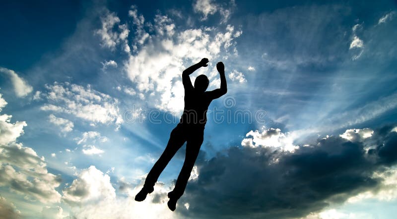 A silhouette of man jumping against blue sky and clouds. A silhouette of man jumping against blue sky and clouds