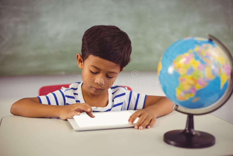 Skolpojke som använder den Digital minnestavlan i klassrum royaltyfri foto Skolpojke som använder den Digital minnestavlan i klassrum royaltyfri foto
