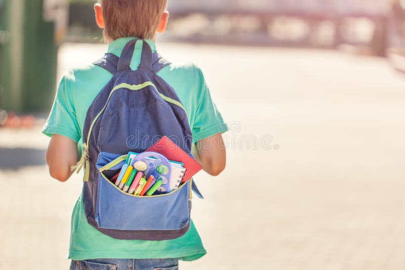 Skolpojken med den fulla ryggsäcken går till skolan tillbaka sikt fotografering för bildbyråer Skolpojken med den fulla ryggsäcken går till skolan tillbaka sikt fotografering för bildbyråer