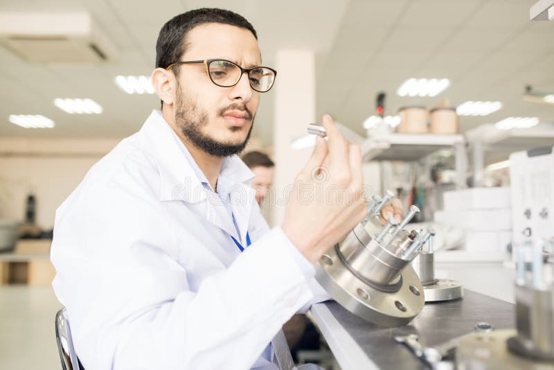 Skoncentrowany Arabski inżyniera viewing szczegół techniczny equipm zdjęcia stock Skoncentrowany Arabski inżyniera viewing szczegół techniczny equipm zdjęcia stock