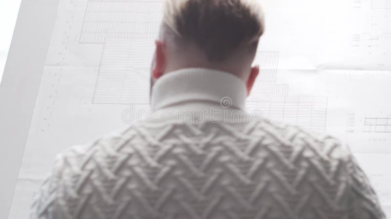 Skoncentrowany architekt pracuje na poddaszu za pomocą tablicy rysunkowej. miejsce pracy młodego inżyniera w nowoczesnym biurze. zbiory