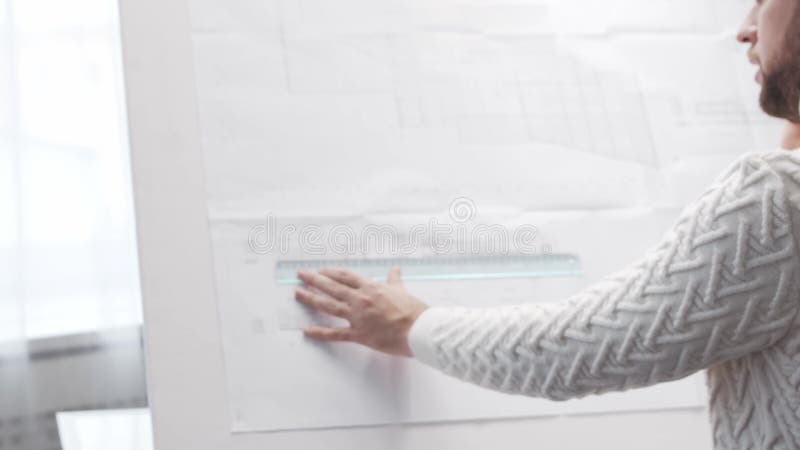 Skoncentrowany architekt pracuje na poddaszu za pomocą tablicy rysunkowej. miejsce pracy młodego inżyniera w nowoczesnym biurze. zbiory wideo