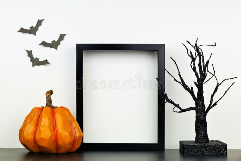 Skopiuj czarną ramę dynią na Halloween i wystraszony dekorator na półce pod białą ścianą zdjęcie royalty free Skopiuj czarną ramę dynią na Halloween i wystraszony dekorator na półce pod białą ścianą zdjęcie royalty free