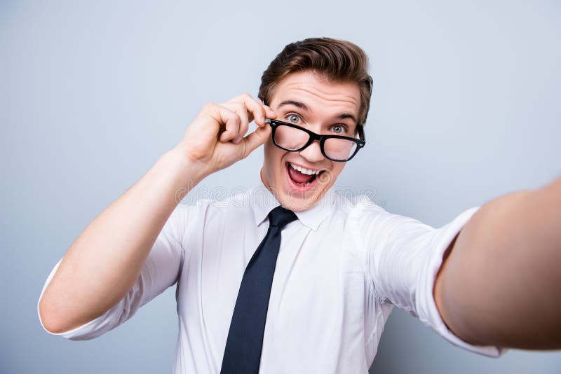 Skraj lynne av en ung man för upphetsad geek i exponeringsglas och formellt oss royaltyfri bild Skraj lynne av en ung man för upphetsad geek i exponeringsglas och formellt oss royaltyfri bild