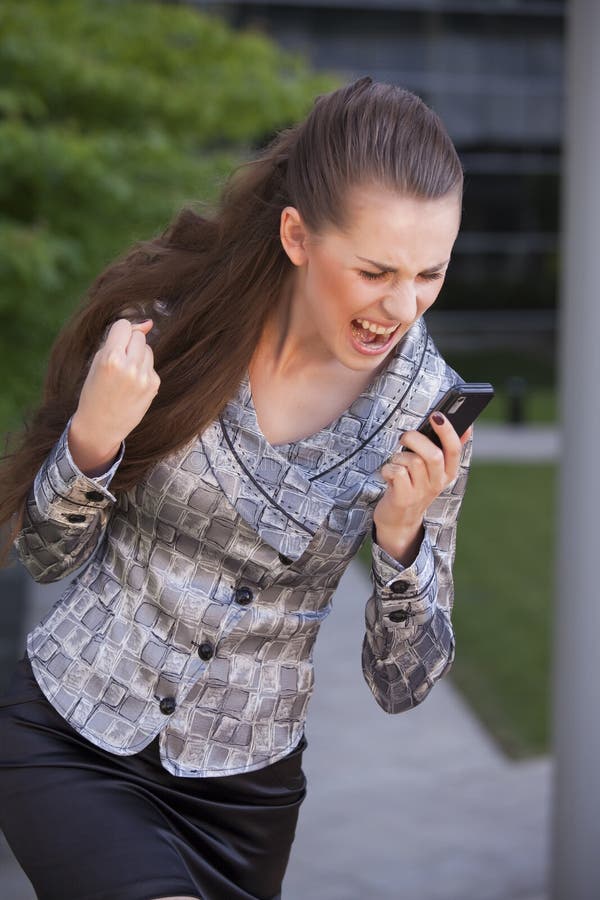 Angry businesswoman screaming on cell phone outdoor. Angry businesswoman screaming on cell phone outdoor