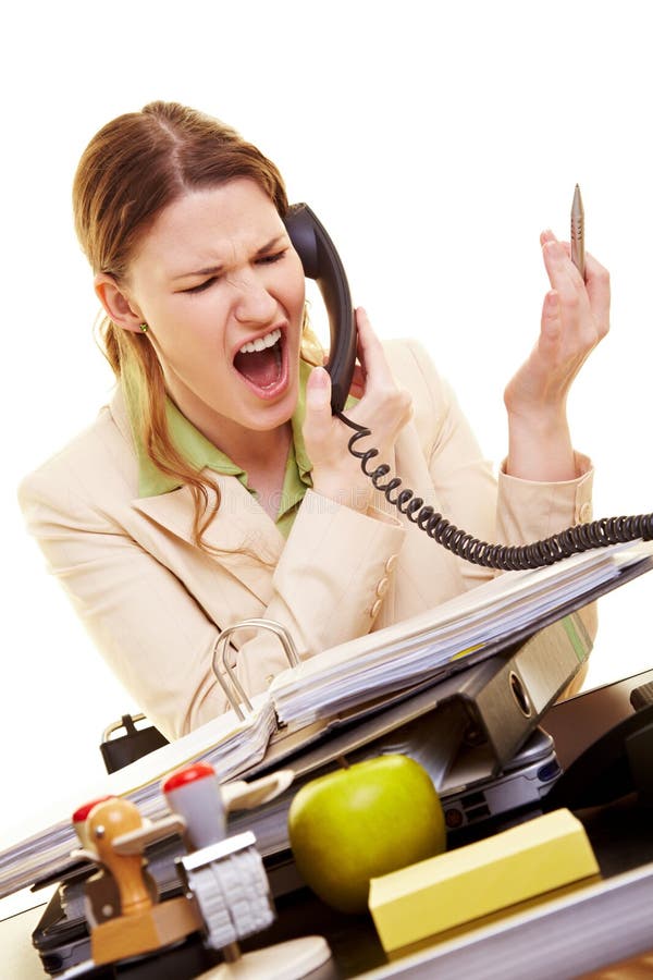 Businesswoman sitting at her desk and screaming into a phone. Businesswoman sitting at her desk and screaming into a phone