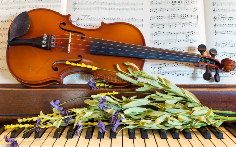 Some spring flowers decorate a violin and piano. Some spring flowers decorate a violin and piano.