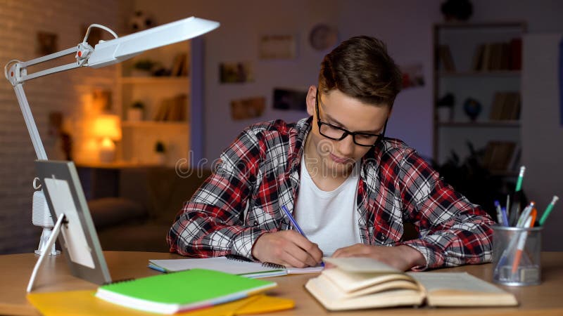 Skrz?tny ucze? robi jego hometask przy kampusem, pracuje na dyplomu projekcie zdjęcie royalty free Skrz?tny ucze? robi jego hometask przy kampusem, pracuje na dyplomu projekcie zdjęcie royalty free
