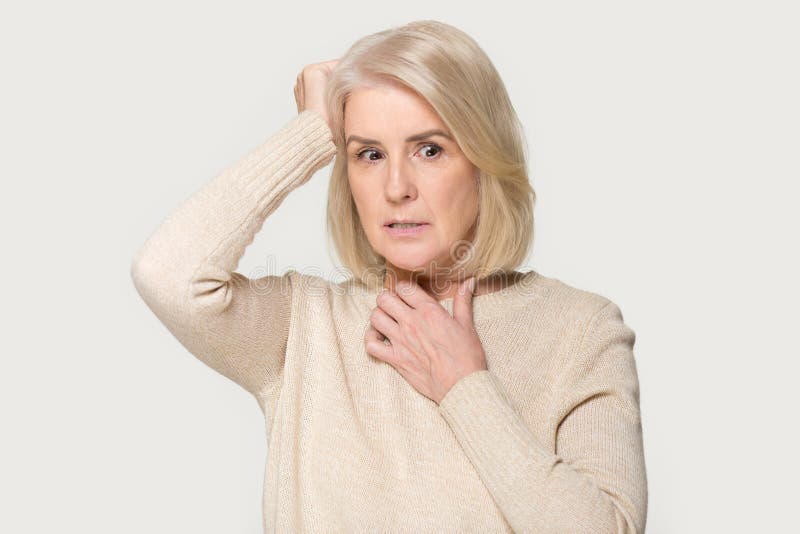 Skrämd gammal kvinna för framsidauttryck som isoleras på grå studiobakgrund arkivfoto Skrämd gammal kvinna för framsidauttryck som isoleras på grå studiobakgrund arkivfoto