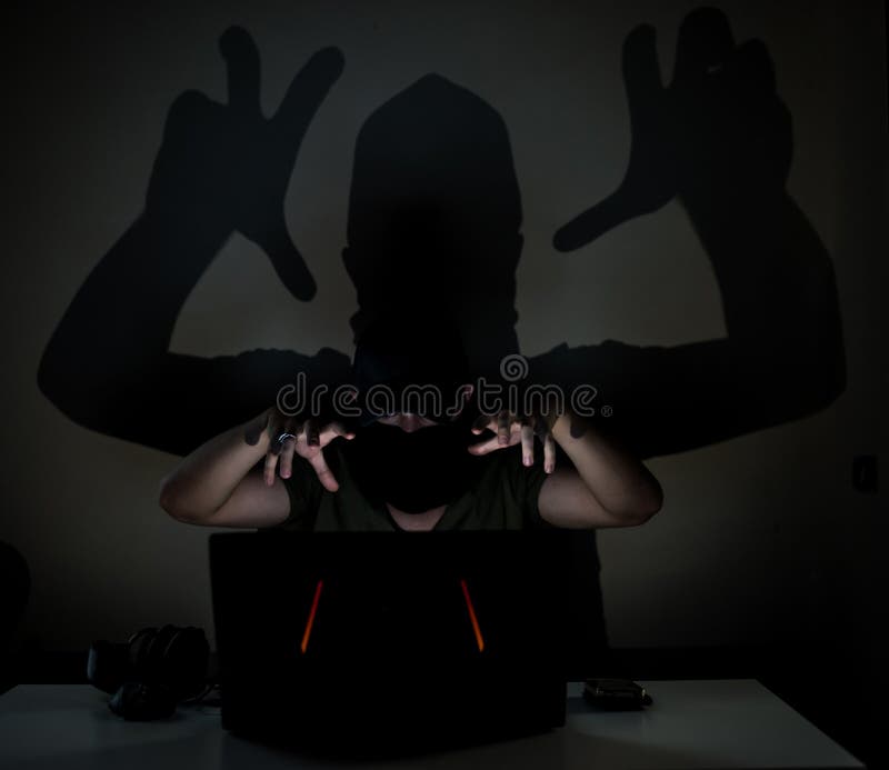 Skuggaen hacker i mörkret arkivfoton Skuggaen hacker i mörkret arkivfoton