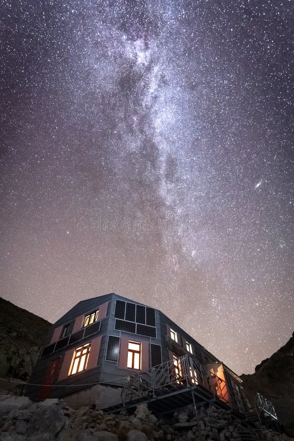 Obloha plná hviezd s mliečnou dráhou nad osvetlenou vysokohorskou chatou, Európa, Slovensko