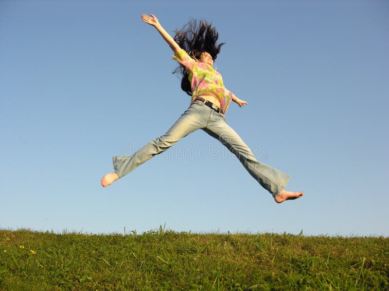 Jump girl with hair on sky green grass. Jump girl with hair on sky green grass