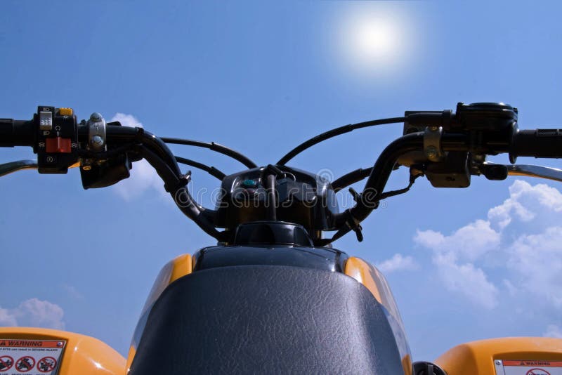 Un ATV, quattro ruote impugnature puntato verso il cielo blu.