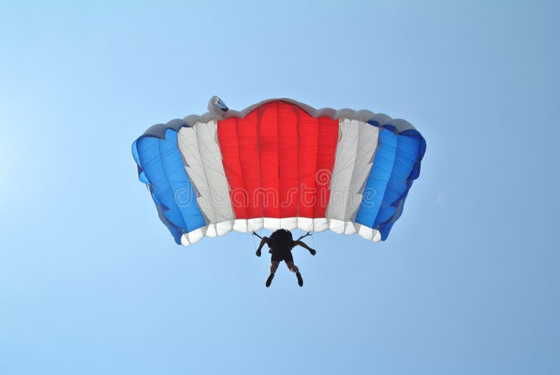Skydiver com saltar em queda livre vermelho branco azul do paraquedas fotografia de stock Skydiver com saltar em queda livre vermelho branco azul do paraquedas fotografia de stock