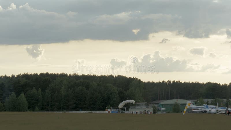 Skydiver is landing on the grass stock footage