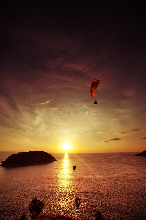 Skydiveren flyger över havet på bakgrunden av solnedgånglodlinjen arkivfoto Skydiveren flyger över havet på bakgrunden av solnedgånglodlinjen arkivfoto