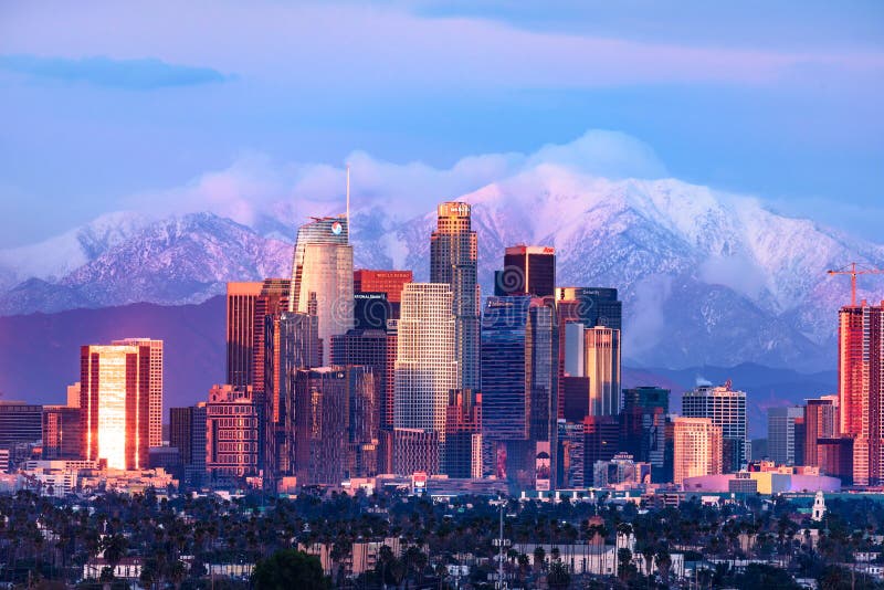 Downtown Los Angeles skyline with snow capped mountains behind at twilight. Downtown Los Angeles skyline with snow capped mountains behind at twilight